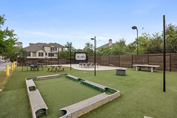 A playground with a green surface and a sign that says